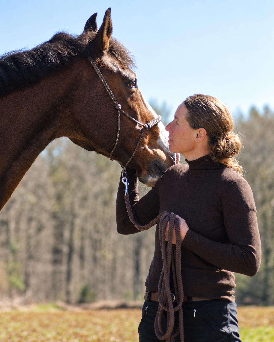Astrid en haar paard staan met hun gezichten dicht bij elkaar